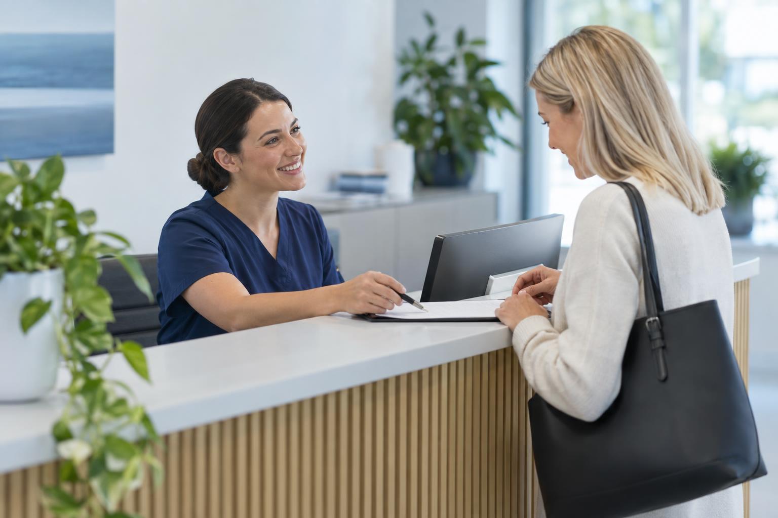 A staff member helps a client at the front desk of a bright wellness clinic